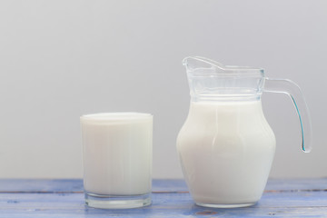 Splash of milk from the milk glass ,Morning milk, Glass jug and glass with milk on a wooden table on white background