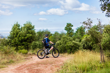 Fototapeta premium Electric mountain bike rider standing at the side of the road, taking a break