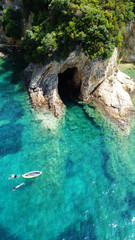Aerial drone photo of natural tropical volcanic caves and emerald sea