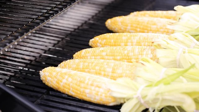 Grilling mexican street corn elote on outdoor gas grill