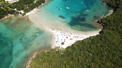 Naklejka na ściany i meble Aerial drone bird's eye view photo of popular and iconic turquoise beach of Bella Vraka in island of Mourtemeno with sunbeds and canoes forming a blue lagoon, Sivota bay, Epirus, Greece