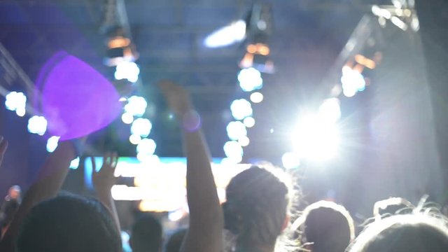 People clap and wave their Hands and dancing at a Gospel Rock Concert