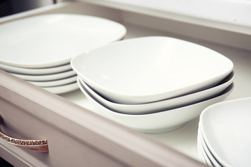 Set of clean plates in kitchen drawer