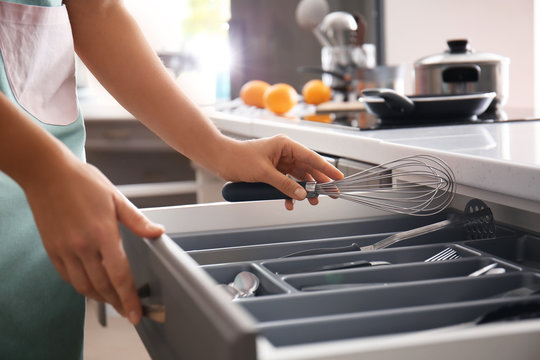 Woman Putting Whisk Into Kitchen Drawer