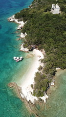 Fototapeta na wymiar Aerial drone bird's eye view of popular beach of Zeri with beautiful emerald sandy beach full of sunbeds and sail boats at summer time, Epirus, Ionian, Greece