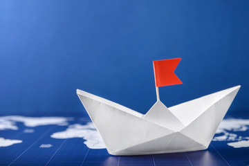 Origami boat on world map. Travel concept