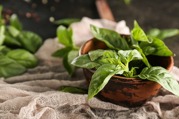 Bowl with fresh green basil on table