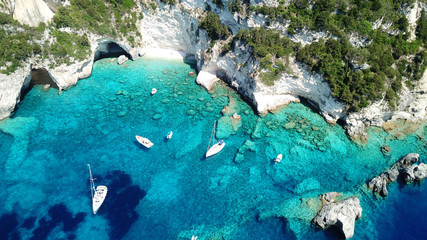 Aerial drone bird's eye view photo of sail boats docked in tropical caribbean paradise bay with...
