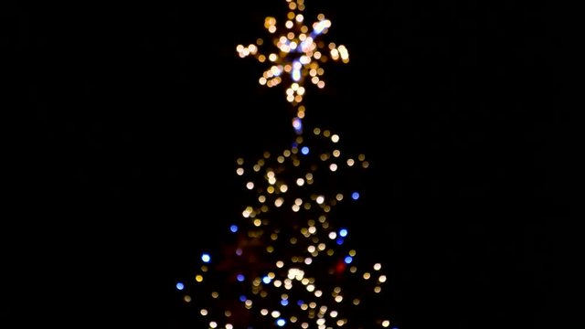 Flashlights of the blurred christmas tree. Falling blue lights.