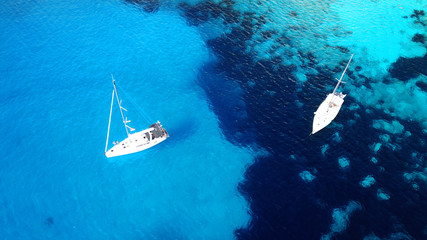 Aerial drone bird's eye view photo of sail boats docked in tropical caribbean paradise bay with...