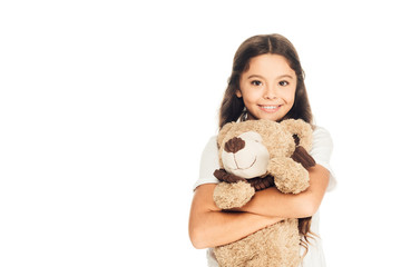 smiling adorable child hugging teddy bear isolated on white and looking at camera