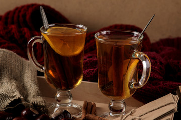 Autumn composition with hot tea yellow leaves and books on a brown wooden table.
