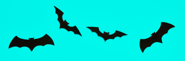 Halloween and decoration concept. Black paper bats flying over pastel blue background. Halloween banner.