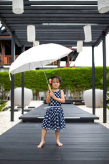 Asian cute girl wearing blue clothes and posing with umbrella