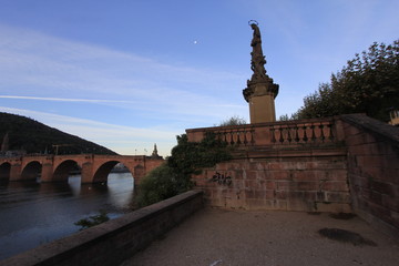 Statue vor alter Brücke und Mond in Heidelberg