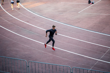 High angle view of male athlete running on race track in stadium