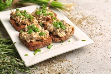 Tasty sandwiches with spread and fresh herbs on plate