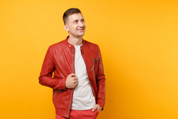 Portrait vogue smiling handsome young man 25-30 years in red leather jacket, t-shirt standing isolated on bright trending yellow background. People sincere emotions lifestyle concept. Advertising area