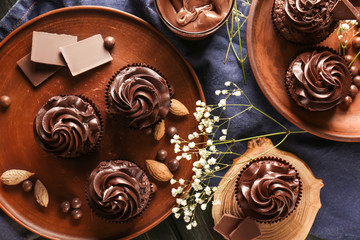 Tasty chocolate cupcakes on table, top view