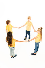 Naklejka premium high angle view of cute happy kids standing together and holding hands isolated on white