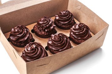 Tasty chocolate cupcakes in cardboard box, closeup