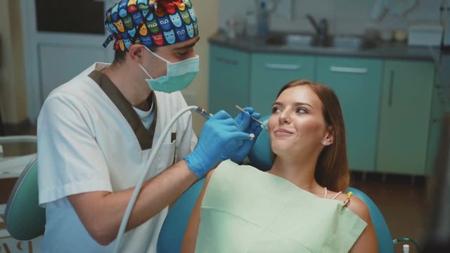 Young pretty girl is in dental cabinet on treatment and consultating. 4K