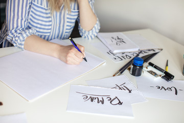 Close up of girl hand writes with brush and inkm lettring process
