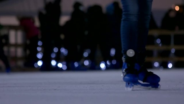 People are training their skating skill. Parents are training their kids how to skate. Close-up view on the ice rink.