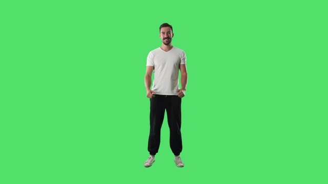 Happy young excited man in sport casual clothes cheering with clenched fists. Full body isolated on green screen background. 