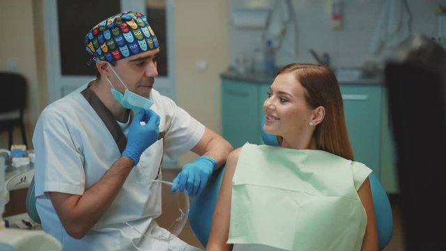 Happy female patient and dentist smiling and showing thumb to camera. 4K