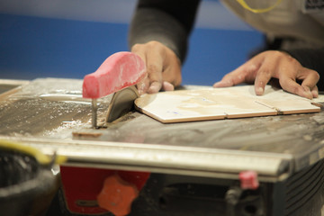 Man to cut tile by chainsaw for To lay out textiles by industrial man for interior decoration