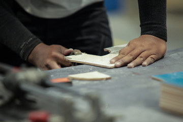 Man to cut tile by chainsaw for To lay out textiles by industrial man for interior decoration