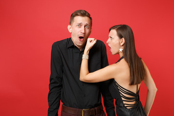 Fun expression young couple in black clothes shirt dress celebrating birthday holiday party isolated on bright red background. St Valentine International Women Day Happy New Year 2019 concept. Mock up