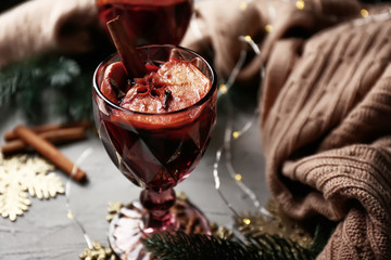 Glass of delicious mulled wine on grey table