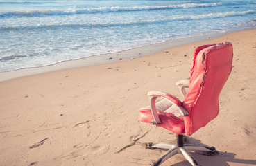 Pink office chair on beach