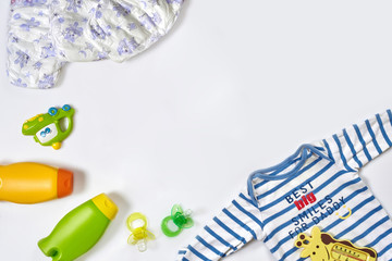 Baby care accessories and clothing on white background, top view