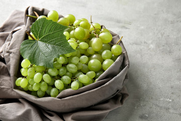 Plate with ripe sweet grapes on grey background
