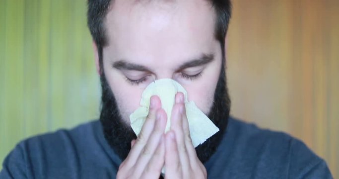 young handsome bearded man blow one's nose . studio. 4k. portrait. Slow motion