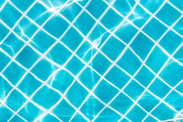 Fototapeta na wymiar Blue tile on swimming pool bottom under clear water with sun light reflection. Travel, vacation concept. Text space.