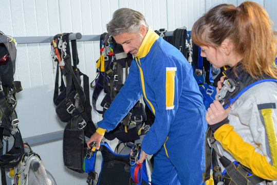 male instructor with female student preparing before skydiving