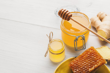 Honey in jar with fresh ginger on vintage wooden background