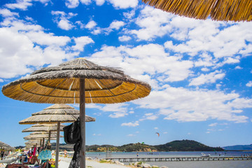 View on the beach with straw umbrella in Talamone, Tuscany - Italy