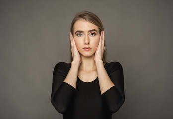 Detached woman covering ears with hands