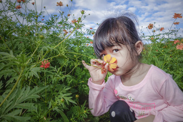 Little girl smell yellow flower