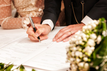 Hands signing during the wedding