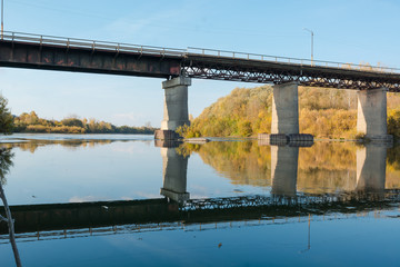 Fototapeta premium Old bridge over the river. Autumn landscape with a bridge