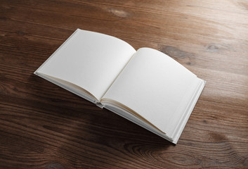 Blank open book or notebook on wood table background. Responsive design mockup.