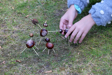Kinderh&auml;nde basteln Figuren mit Kastanien