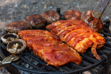 Barbecue grill outdoor, close up.  Various meat marinated grilling. Selective focus.