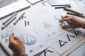 Fotobehang Graphic designer development process drawing sketch design creative Ideas draft Logo product trademark label brand artwork. Graphic designer studio Concept. © Chaosamran_Studio